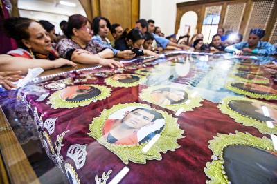 Familieleden van de koptische martelaren bidden tijdens hun begrafenis in al-Our in Egypte.  © Belga Image